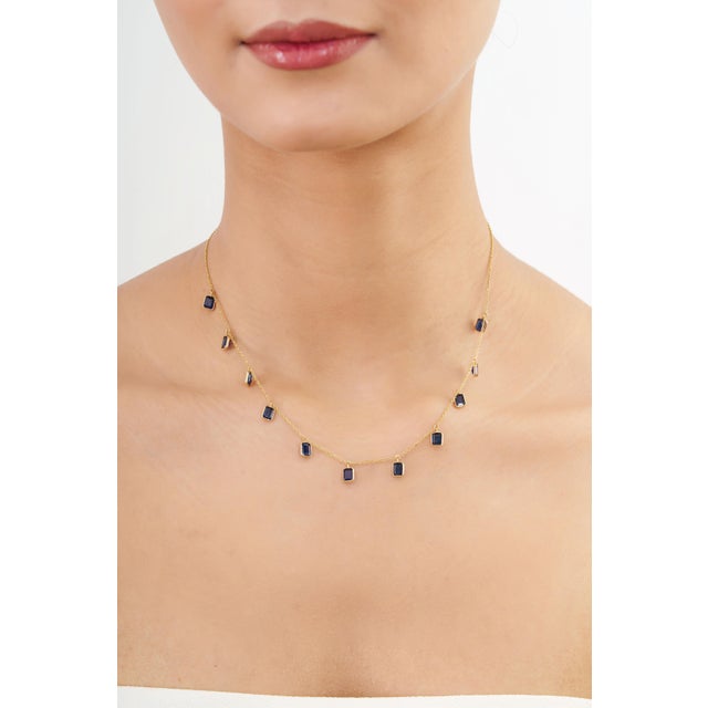 Add timeless elegance to your jewelry collection with this beautiful 14K yellow gold blue sapphire charm necklace....