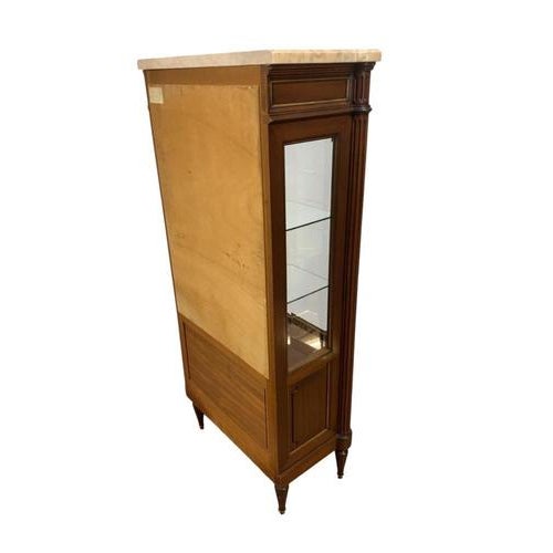 A fine French Directoire style vitrine cabinet in mahogany, surmounted by a shaped white marble top above a glazed display...