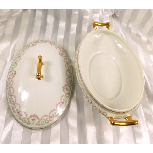 This is a white oval Elite Limgoes covered casserole dish in an unknown pattern. The dish has a pattern of swags of pink...