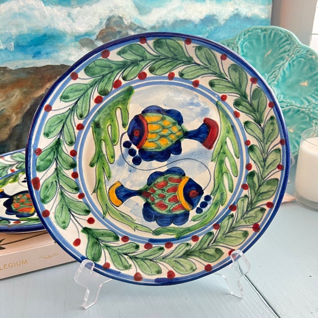 Set of 4 hand-painted Mexican Talavera earthenware plates featuring a colorful dual-fish motif framed by a vibrant green...