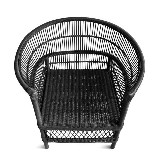 Vintage hand woven black wicker horseshoe chair. Okay for outdoor use under covered area. Each chair may vary in natural...