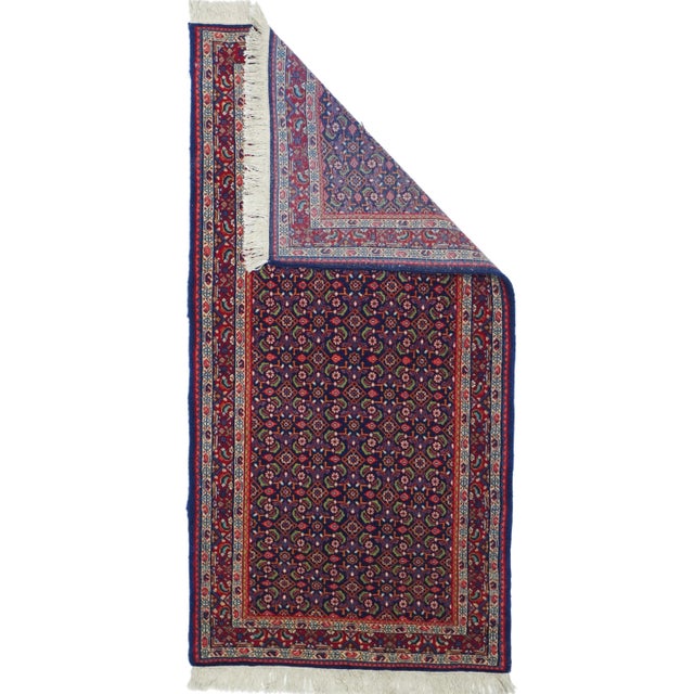 The very dark navy field hosts a close and even allover Herati design with ivory rosettes, open diamonds and fat, short...