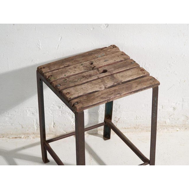 This antique industrial stool in pine wood and iron is an industrial seat with a tubular iron frame and a pine slatted...