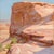 This gouache painting captures the rugged beauty of a desert landscape, focusing on the warm, earthy tones of a towering...