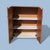 A compact vintage storage cabinet with clean mid-century lines, a warm teak laminate finish and two doors fitted with...