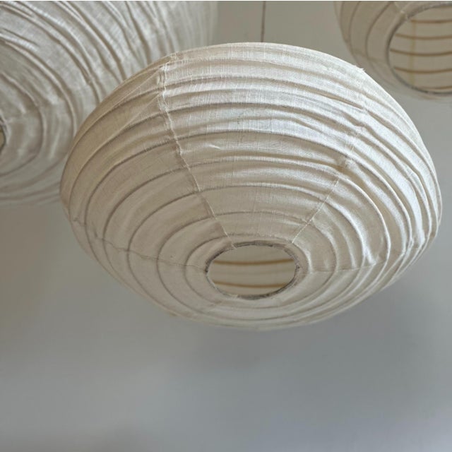Medium-sized, oval, flattened pendant light in Japanese-style rattan and natural linen. Beautifully handcrafted: natural...