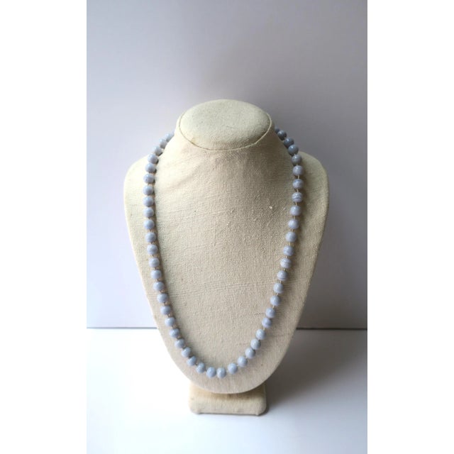 A beautiful chalcedony quartz bead necklace, circa mid to late-20th century. Beads are a light periwinkle blue, polished...