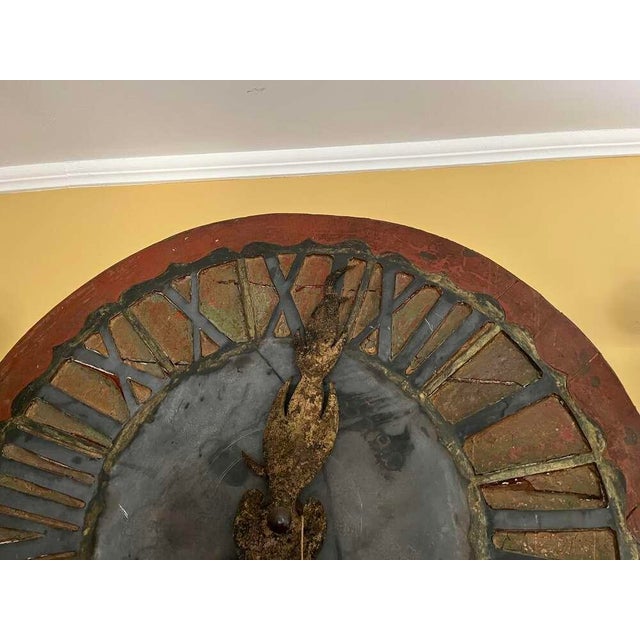 Striking antique French clock face featuring beautifully aged, hand-painted surfaces in rich red and muted blue tones,...