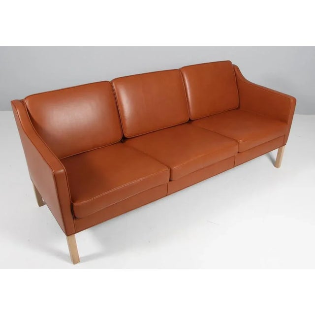 Børge Mogensen three-seat sofa new upholstered with cognac pure aniline leather. Legs of soap treated oak. Model 2323,...