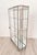 A brushed steel mirrored French display case / vitrine, circa 1920. On turned tapered Louis XVI–style feet. An elegant,...