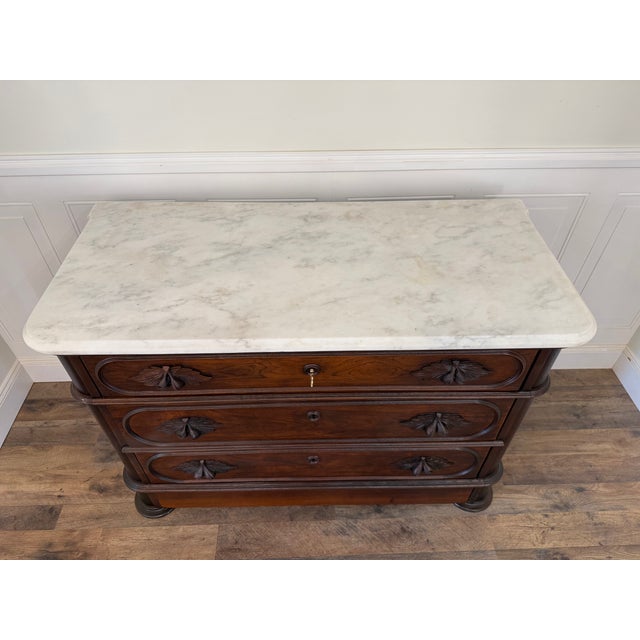 A beautifully restored American Renaissance Revival marble-top chest, believed to made between 1855-1875, showcasing the...