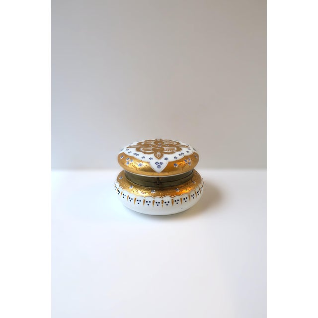 A beautiful, relatively large, white opaline glass vanity jewelry box, hand-decorated with raised gold gilt and tiny blue...