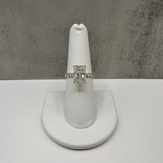 This stunning radiant cut lab grown diamond engagement ring is crafted in 14K yellow gold and features a 3.04 carat IGI...