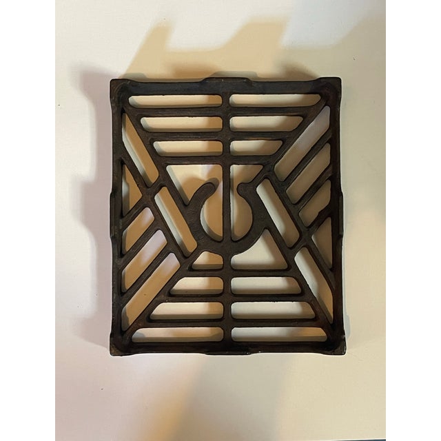 An interesting early 20th century cast iron trivet with a geometric line-work pattern.