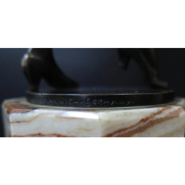 This Art Deco bronze sculpture depicts a costumed dancer mounted upon a marble base. The figure bears the artists...