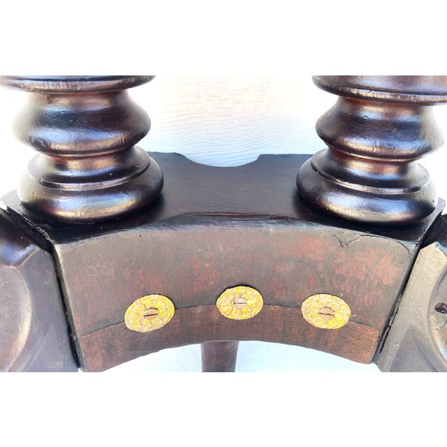 This piece features a sculptural base with carved lion-paw feet, turned columns, and a distinctive architectural...