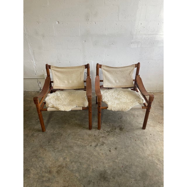 Pair of Arne Norell Sirocco Armchairs. Original canvas. Made in Sweden. Sheepskin throws included. Inspired by safari...
