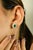 Exquisitely crafted in 18K yellow gold, these elegant stud earrings feature vibrant emeralds weighing a total of 1.28...