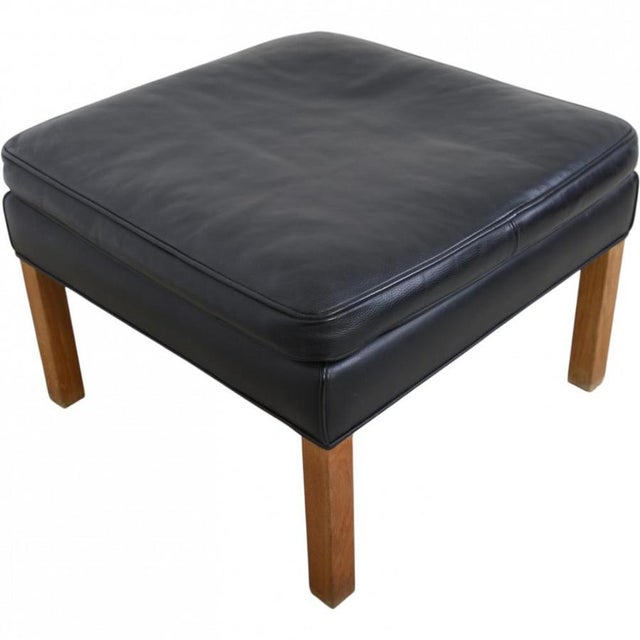 Børge Mogensen 2202 stool upholstered in original black leather and with legs of oiled oak. The stool is from around 2020...