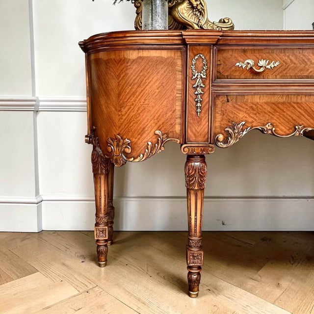 This exceptional Louis XV style sideboard features richly figured book matched mahogany veneers with mirrored chevron...