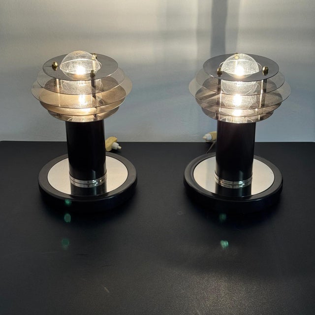 A pair of vintage "Saturne" table lamps, so named for their overlapping disc lampshades reminiscent of the rings of the...