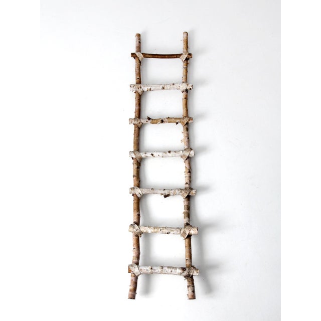 Vintage handmade birch blanket ladder with seven rungs, natural birch bark, and rustic bark tie wraps at the joints. A...