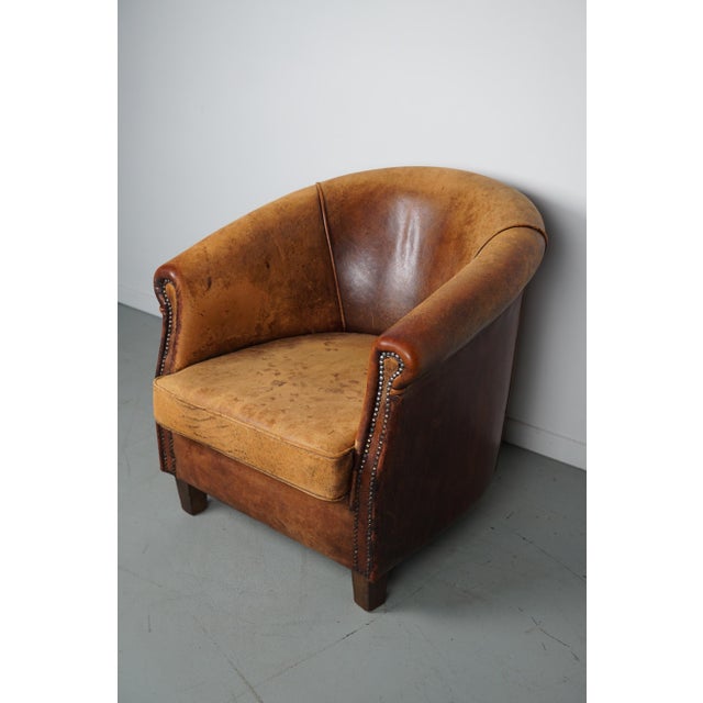 This cognac-colored leather club chair comes from the Netherlands. It is upholstered with cognac-colored leather and...