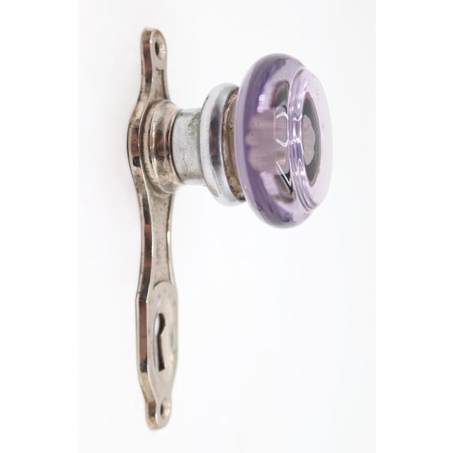 Art Deco style round shaped purple glass door knob with a nickel plated brass back plate. The original mounting screws are...