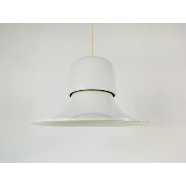 White pendant lamp in the style of Stilnovo made in Italy in the 1950s. The light has the shape of a witches has. It is...