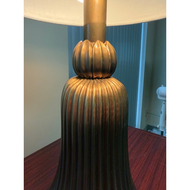 Art Deco-inspired table lamp by Haig, featuring a sculptural fluted brass body with a distinctive tapered form. The deeply...