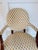 Elegant vintage accent chair featuring a round back, dark wood arms and legs, and a charming tulip-patterned upholstery in...