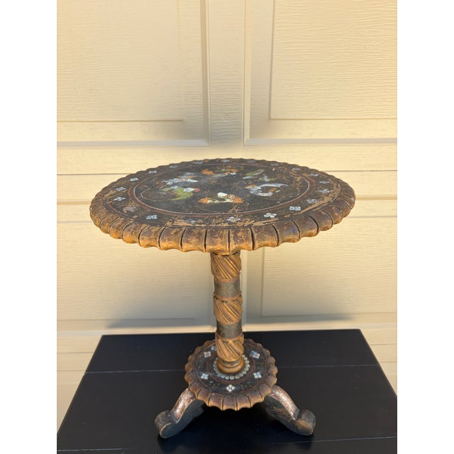 An exceptionally charming early 20th century chinoiserie painted wood drinks table featuring a richly patinated black...