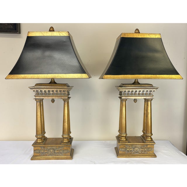Striking pair of French Empire style bouillotte lamps from the late 20th century. They are made of heavy wood in a gold...