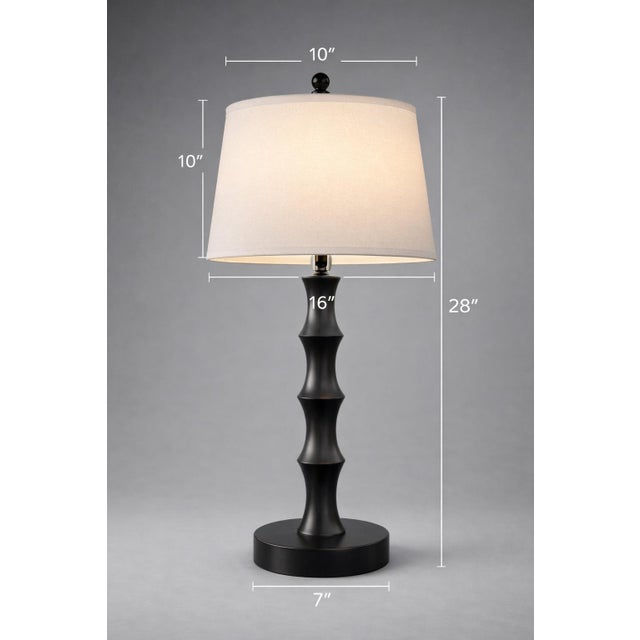 A sculptural pair of matte black turned wood table lamps with warm linen shades—clean, architectural, and perfectly scaled...