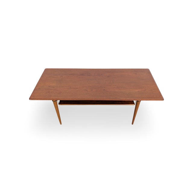 We are offering a beautiful teak mid-century coffee table from the 1960s for sale. The design is reminiscent of Peter...