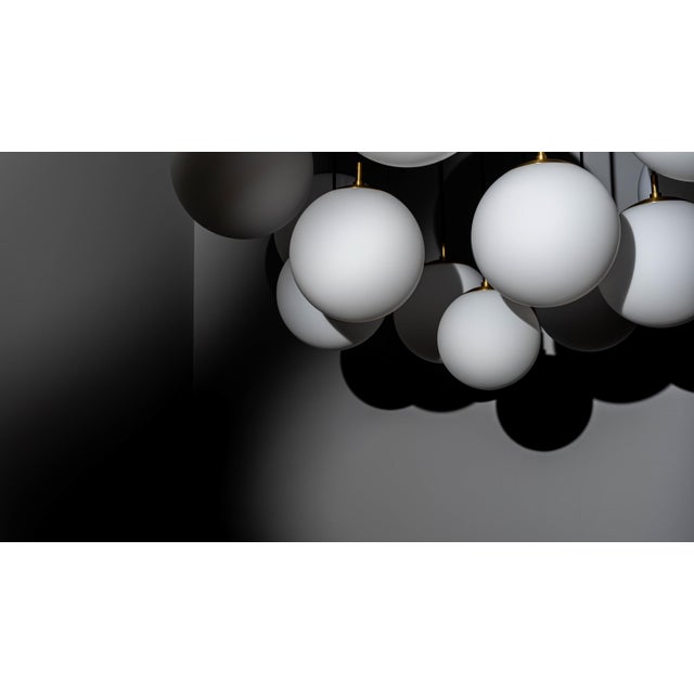 Offered by Schwung An array of thirteen globes hangs in dramatic suspension. The spectacular drape of the dark cables...
