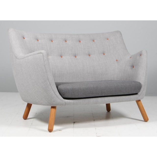 Finn Juhl "Poet" two seat love seat sofa. Legs og oak. Original upholstered with two colours of fabric. Leather buttons...