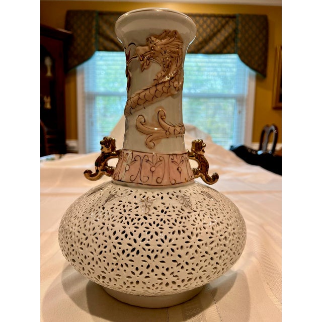 Beautiful Chinoiserie white & pink riticulated Chinese long neck vase w/gold dragon handles and stand. Dimensions: 12”h x...