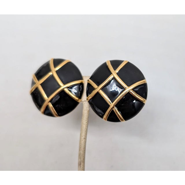 1980s goldtone round domed black enamel clip earrings. Marked "courrèges paris" inside the back. Measure: 1 5/16 inches...