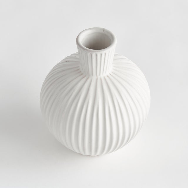 This bottle shaped, ribbed vase is a sweet little accent for bookshelf, desk or kitchen counter. Add a single faux stem...