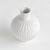 This bottle shaped, ribbed vase is a sweet little accent for bookshelf, desk or kitchen counter. Add a single faux stem...