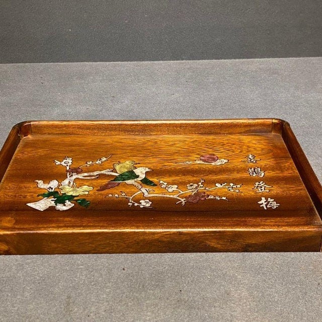 This elegant rectangular serving tray is handcrafted from warm rosewood with raised edge framing. The surface features...