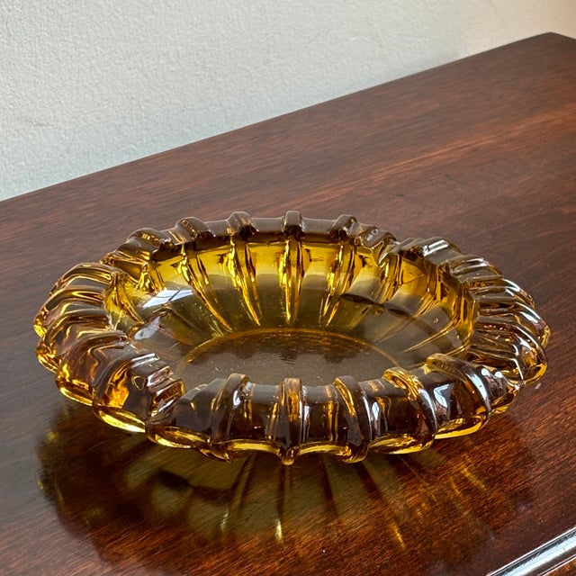 A gorgeous circa 1960 Mid-Century Modern glass sunburst ashtray in a warm amber. Gorgeous color and in excellent vintage...