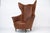 Beautiful mid-century wingback armchair manufactured in Italy in the 1950s. This elegant piece features a sculptural high-...