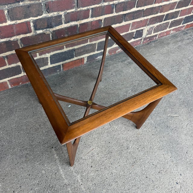 Sculptural Mid-Century Modern walnut and glass side table from Lane Furniture’s Silhouette collection, designed by Andre...