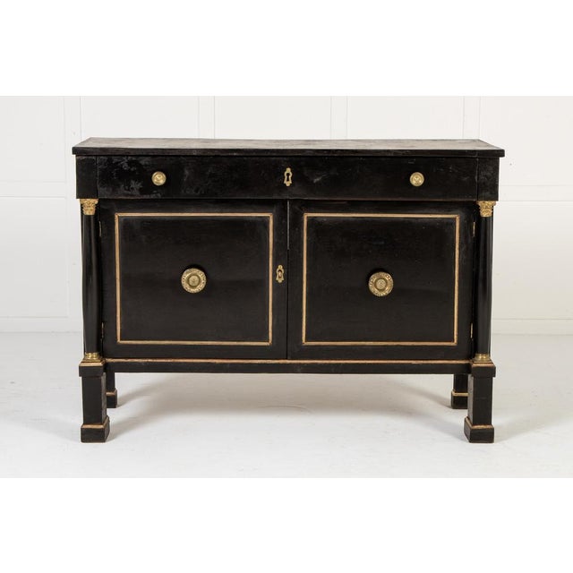 A pair of 18th century italian ebonised cabinets. rectangular in shape, the commodes have architectural column trusses...