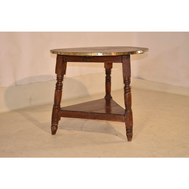 Early 19th century pine cricket table from England. The top is banded in brass to prevent shrinkage and add a bit of...