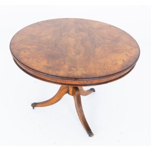 A fine figured oak Regency Revival dining table of exceptional presence, raised upon elegantly swept and fluted legs,...