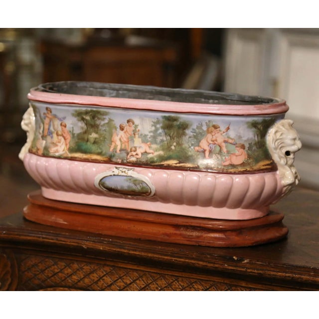 Richly decorated with pastoral scenes and soft pastel colors, this antique faience jardinière is a wonderful example of...