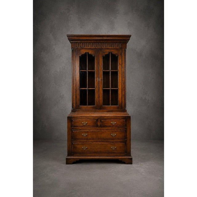 A superb Old New England-style oak housekeeper’s cabinet, combining elegant display storage with practical drawer space....